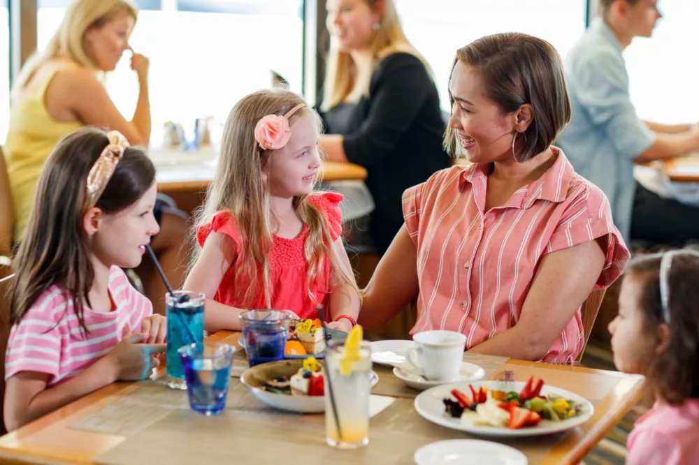 Family mum and kids children daughter having Top Deck Lunch on dining table with food